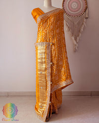 Orange gaji silk saree on mannequin showcasing Gharchola pattern and gota patti embellishment