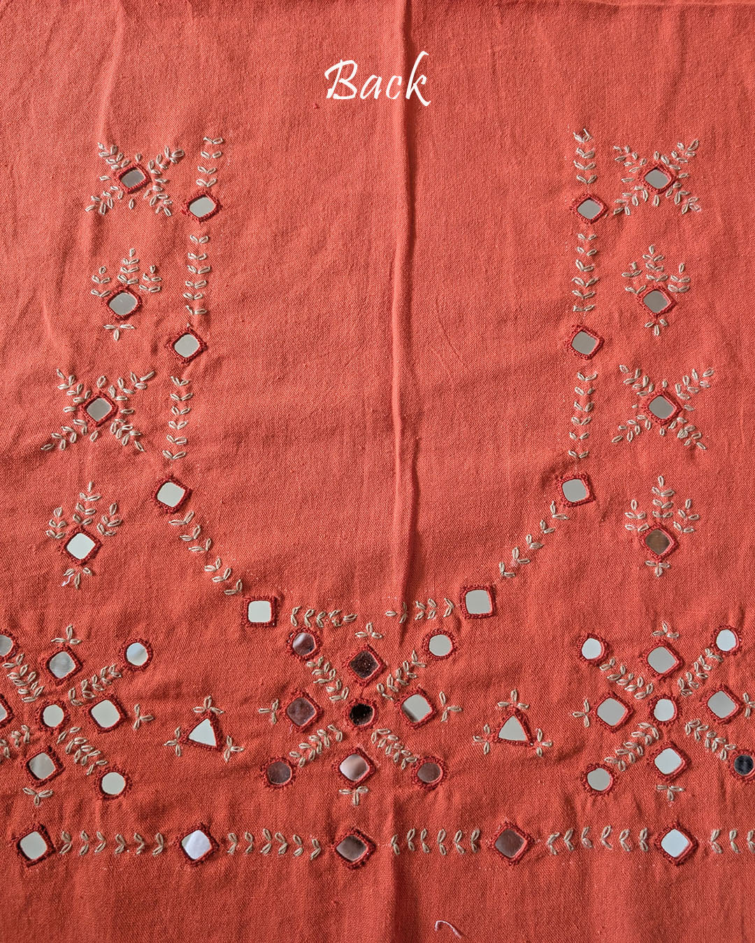 Back view of the Orange Kala Cotton Kutch Mirror Handwork blouse piece, showcasing intricate traditional embroidery and real mirrors arranged in a decorative handcrafted design.