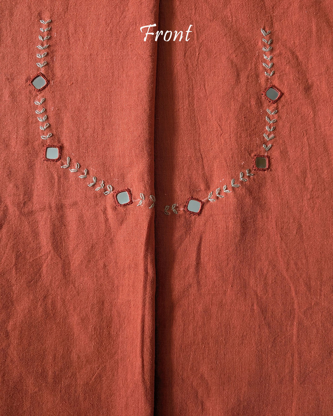 front neck of the Orange Kala Cotton Kutch Mirror Handwork blouse piece, showcasing intricate traditional embroidery and real mirrors arranged in a decorative handcrafted design.