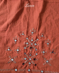 Sleeve detail of the Orange Kala Cotton Kutch Mirror Handwork blouse piece, highlighting the real mirror embellishments, decorative threadwork and vibrant orange Kala Cotton fabric.