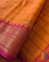 Orange Kanchi cotton saree close up highlighting checkered pattern and fabric texture