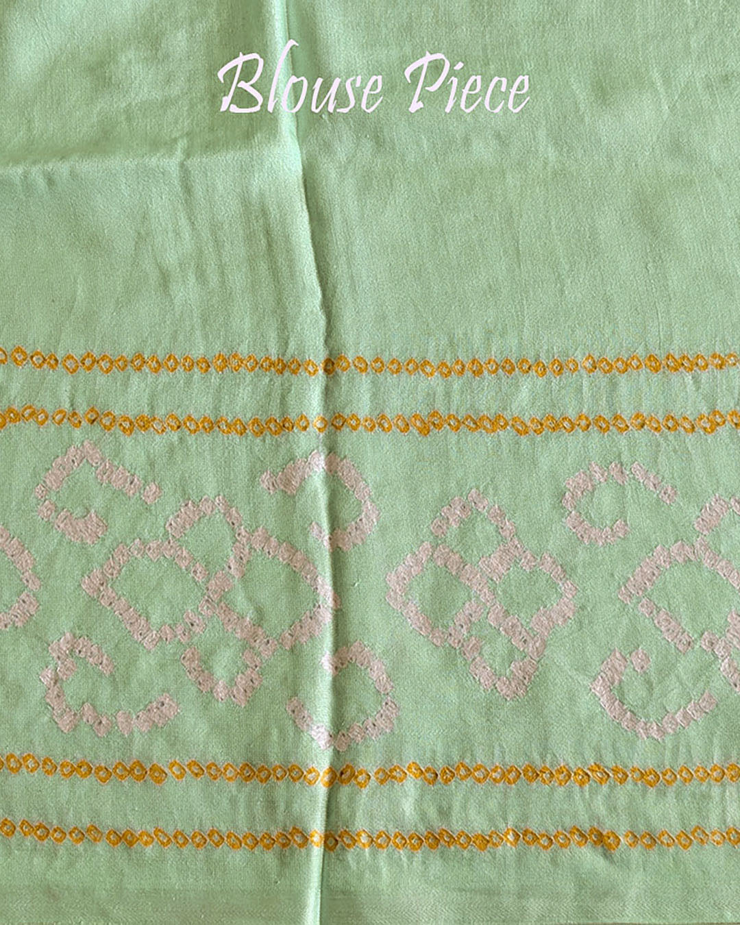 Matching blouse piece in pastel green Gharchola bandhani silk showing fabric