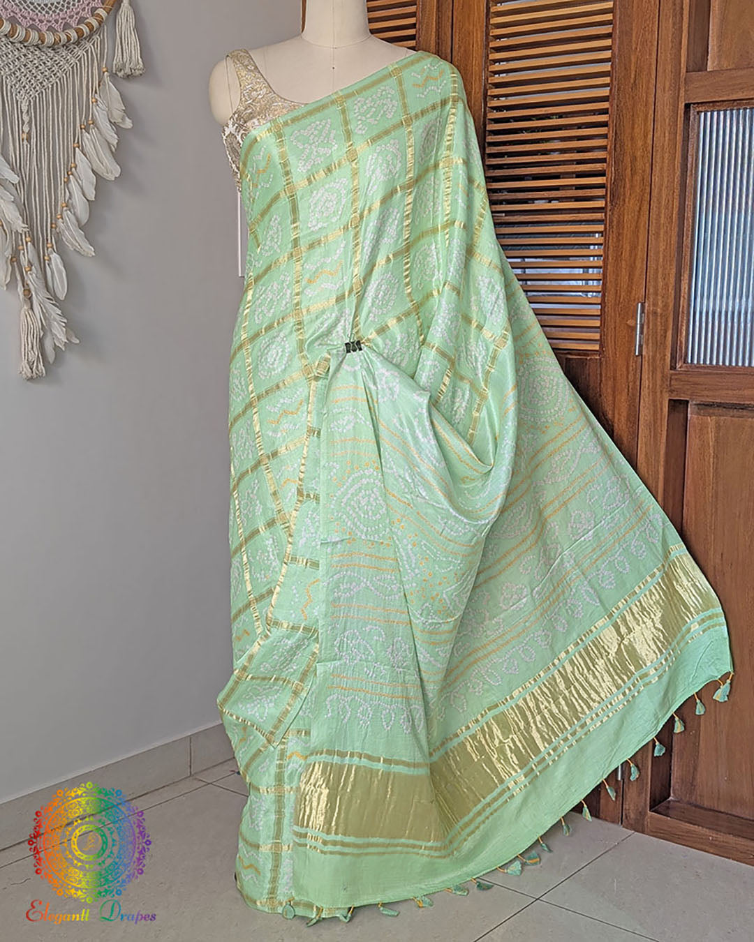 Palla view of pastel green bandhani saree on mannequin highlighting palla fall