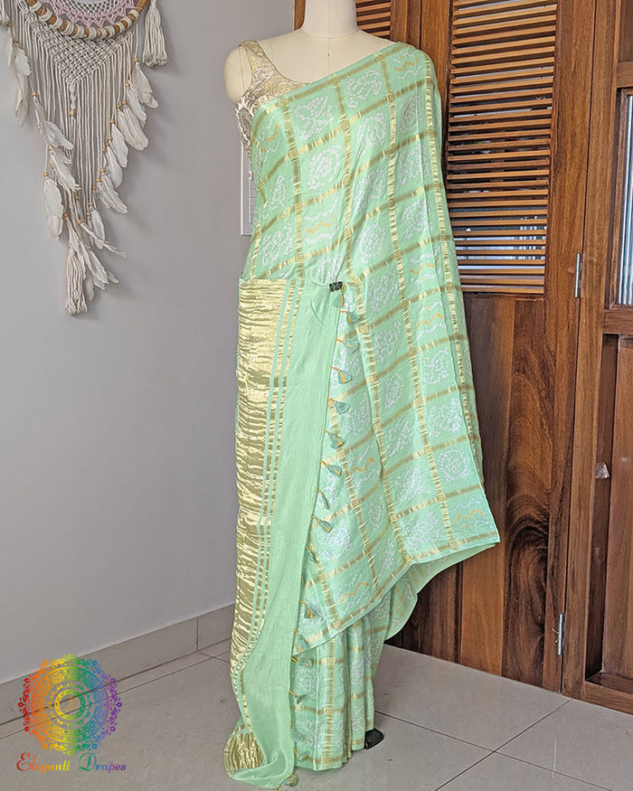 Pastel green Gharchola gaji silk bandhani saree on mannequin showing full drape