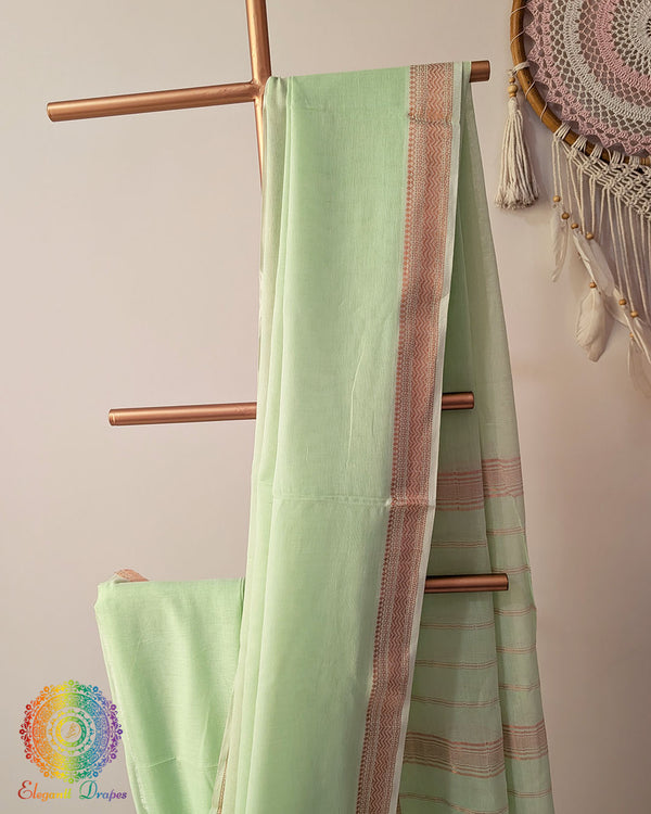 Pastel green Bengal cotton saree body close up highlighting fabric texture with zari border detail