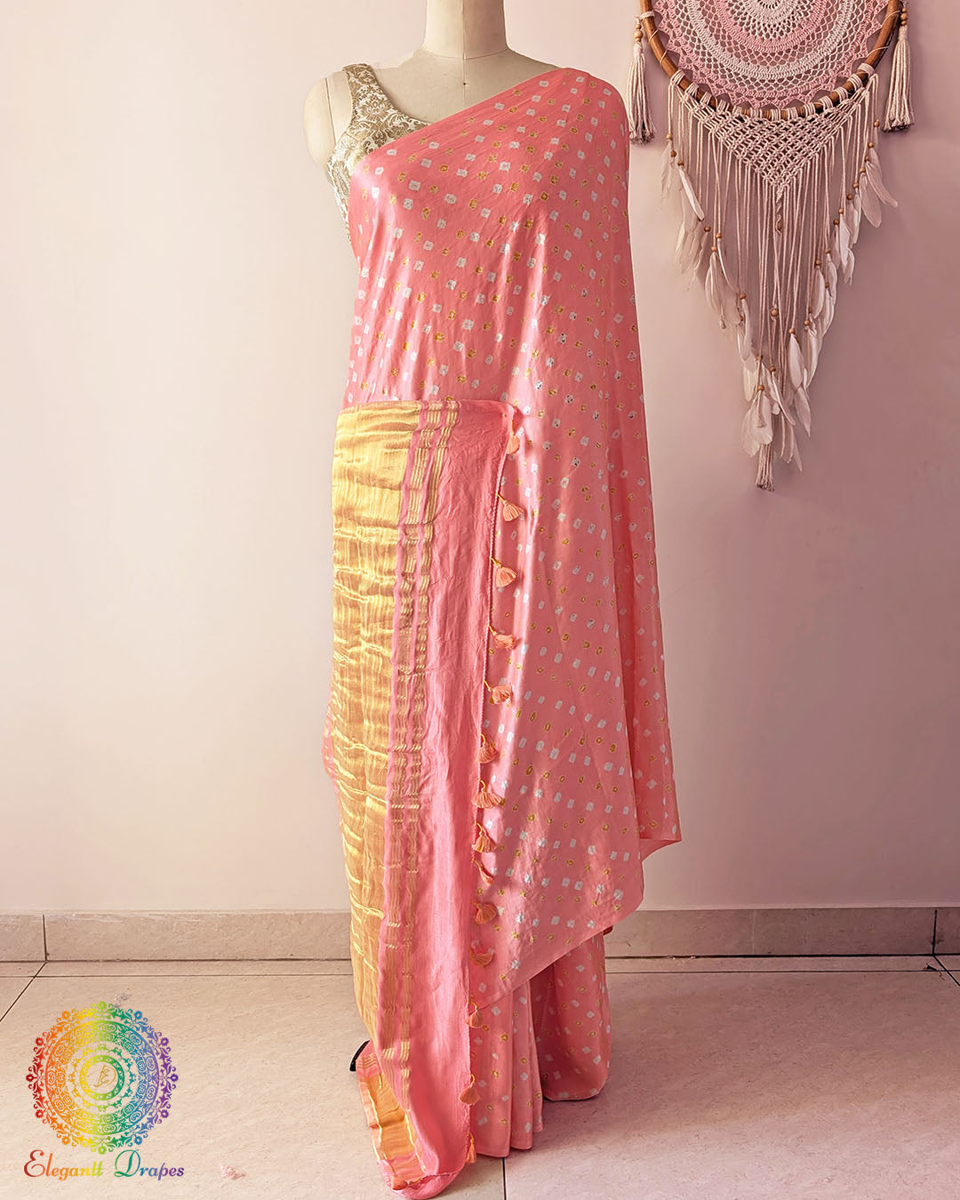 Pastel peach gaji silk saree on mannequin showcasing traditional bandhani dots