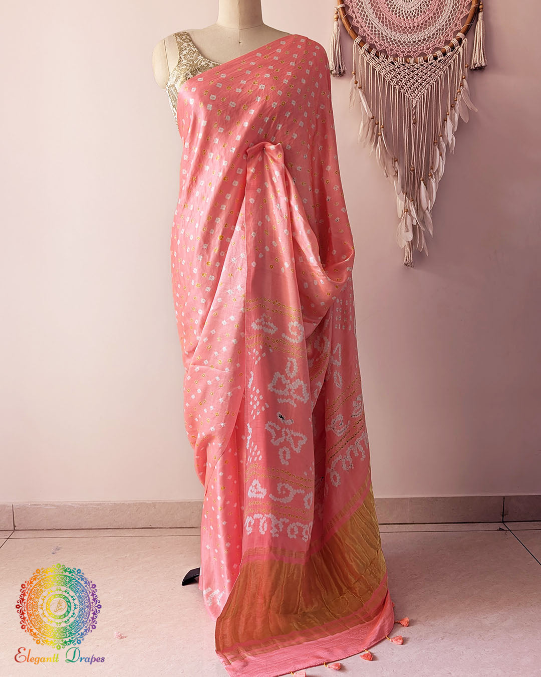 Pastel peach pure gaji silk saree with all-over bandhani dots on mannequin showing full drape