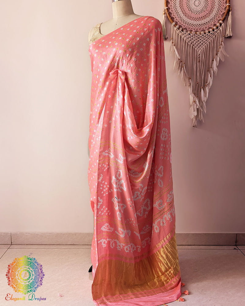 Side angle view of pastel peach bandhani saree highlighting fluid silk drape