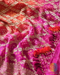 Close up of traditional Bandhani motifs on the pink orange shaded Khaddi georgette Banarasi saree