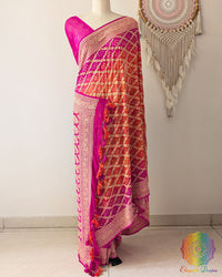 Pink orange shaded Khaddi georgette Banarasi Bandhani saree on mannequin showing full drape and handcrafted heavy tassels