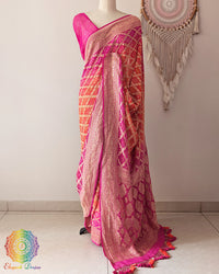 Pink orange shaded Khaddi georgette Banarasi Bandhani saree highlighting the Banarasi woven palla and handcrafted heavy tassels