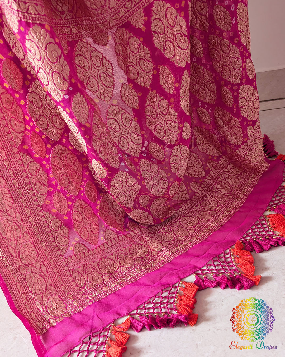 Close up of the Banarasi woven palla with handcrafted heavy tassels on the pink orange shaded Khaddi georgette saree