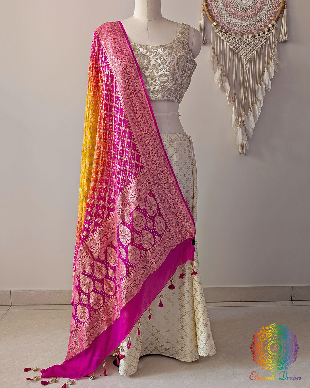 Pink orange shaded Banarasi georgette Gharchola Bandhani dupatta draped on mannequin with zari border and kodi tassels