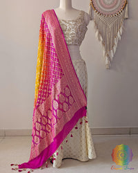 Pink orange shaded Banarasi georgette Gharchola Bandhani dupatta draped on mannequin with zari border and kodi tassels