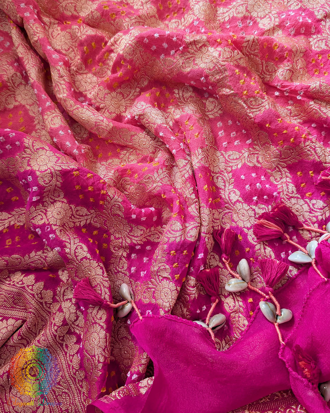 Close-up of traditional kodi tassels, zari border, and Bandhani motifs on pink peach shaded Banarasi georgette Gharchola dupatta
