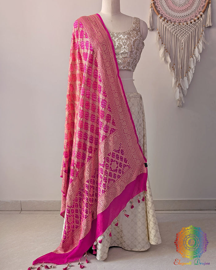 Pink peach shaded Banarasi georgette Gharchola Bandhani dupatta draped on mannequin with zari border and kodi tassels