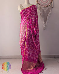 Pink shaded gaji silk saree on mannequin showcasing traditional bandhani dots