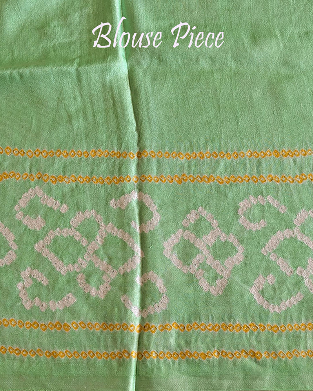 Matching blouse piece in mint green Gharchola bandhani silk showing fabric