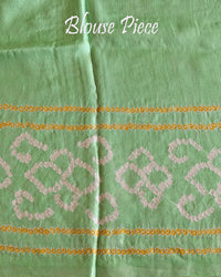Matching blouse piece in mint green Gharchola bandhani silk showing fabric