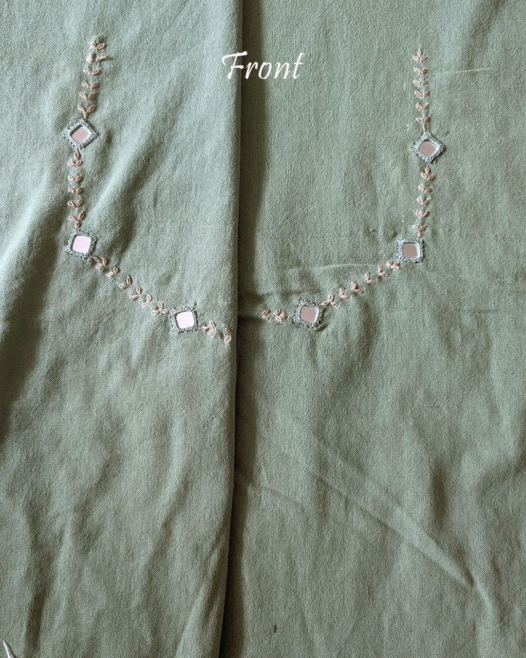Front neck view of the Pista Green Kala Cotton Kutch Mirror Handwork blouse piece, showcasing detailed traditional embroidery and real mirrors arranged in a decorative handcrafted design.