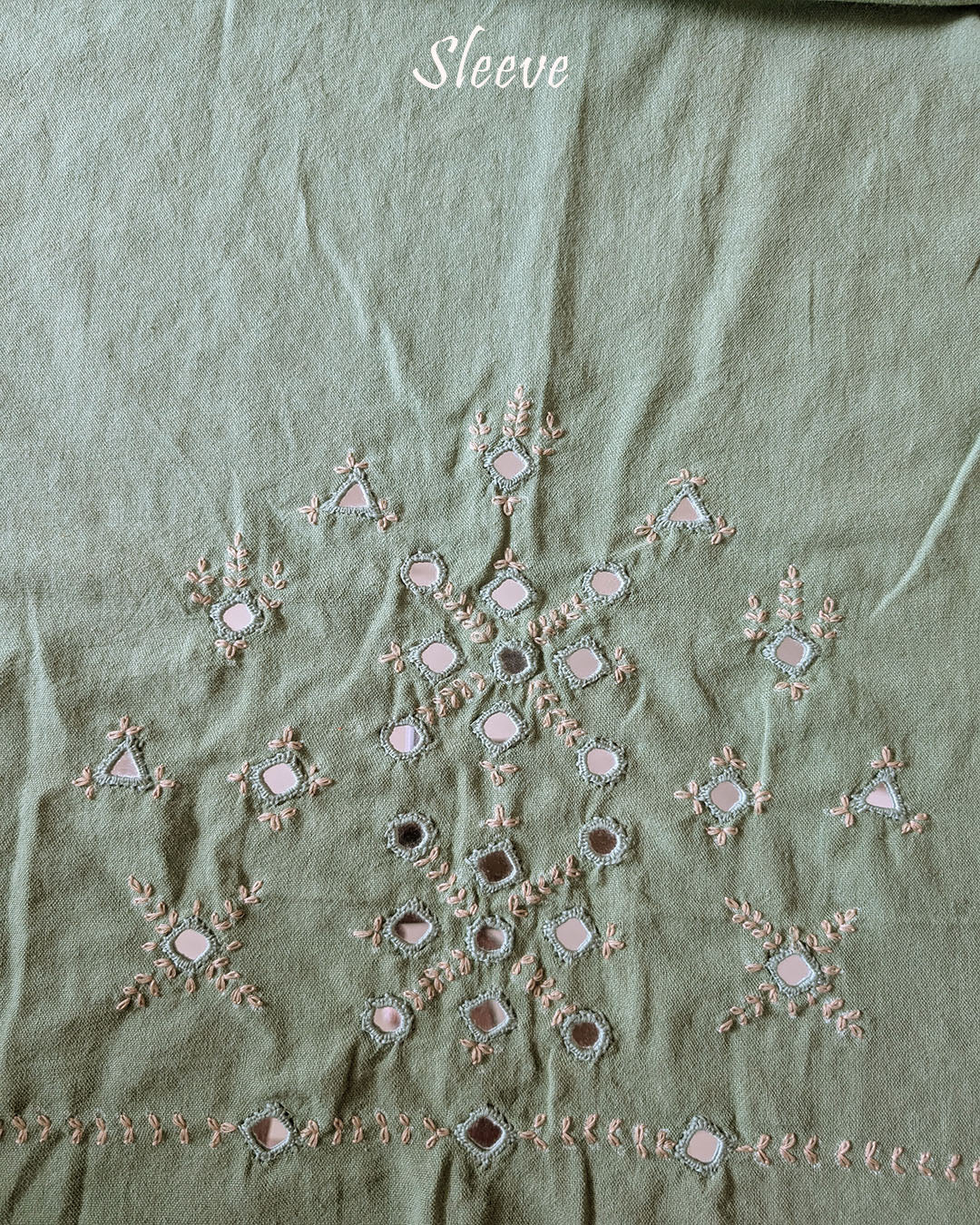 Sleeve detail of the Pista Green Kala Cotton Kutch Mirror Handwork blouse piece, highlighting the real mirror embellishments, intricate threadwork and soft pista green Kala Cotton fabric.