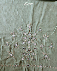 Sleeve detail of the Pista Green Kala Cotton Kutch Mirror Handwork blouse piece, highlighting the real mirror embellishments, intricate threadwork and soft pista green Kala Cotton fabric.