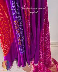 Pleats close up on magenta gaji silk Rasmandal saree showcasing multicolored motifs and intricate gota patti border work