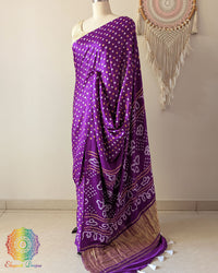 Side angle view of purple bandhani saree highlighting fluid silk drape