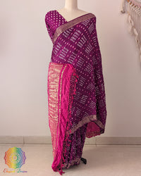 Purple gaji silk Bandhani saree showcasing elegant drape, pink palla, and Nakshi border