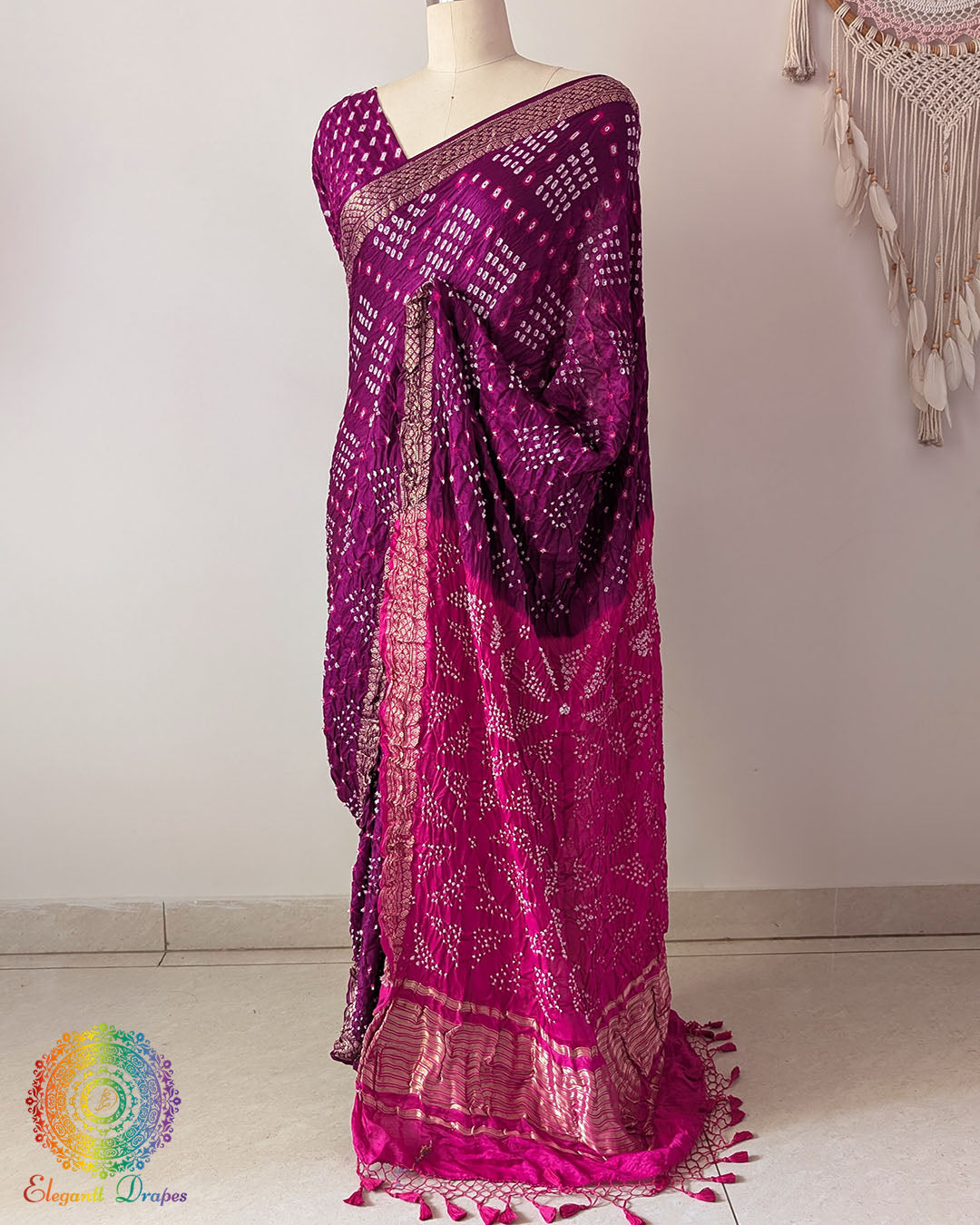 Pink palla on purple gaji silk saree highlighting Bandhani craftsmanship and Nakshi border