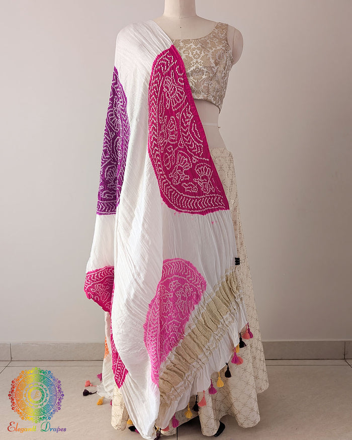 White Gajji Silk Purple Pink Orange Bandhani Dupatta in a full draped view, showcasing the white base decorated with vibrant purple, pink and orange Bandhani patterns.