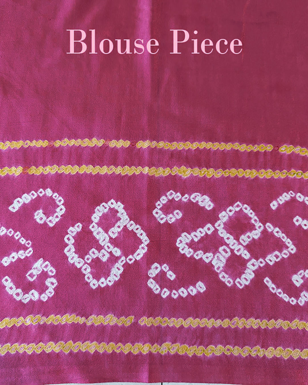 Matching blouse piece in magenta Gharchola bandhani silk showing fabric and pattern