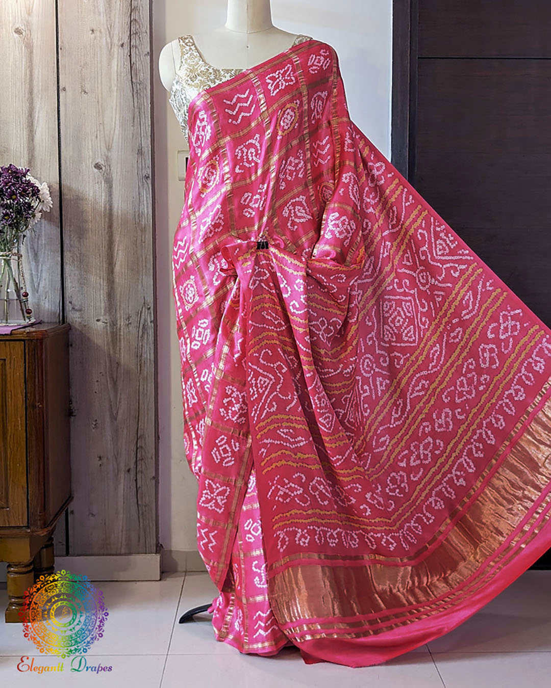 open palla view of magenta Gharchola bandhani saree on mannequin highlighting palla fall