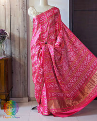 open palla view of magenta Gharchola bandhani saree on mannequin highlighting palla fall