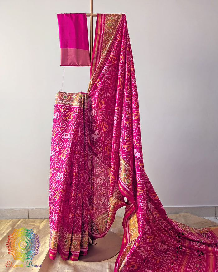 Rani Pink Handwoven Mulberry Silk Rajkot Patola Saree – Full Drape View showcasing the vibrant Rani Pink colour, traditional Rajkot Patola motifs and graceful drape of the handwoven mulberry silk saree, highlighting its rich colour and elegant traditional appeal.