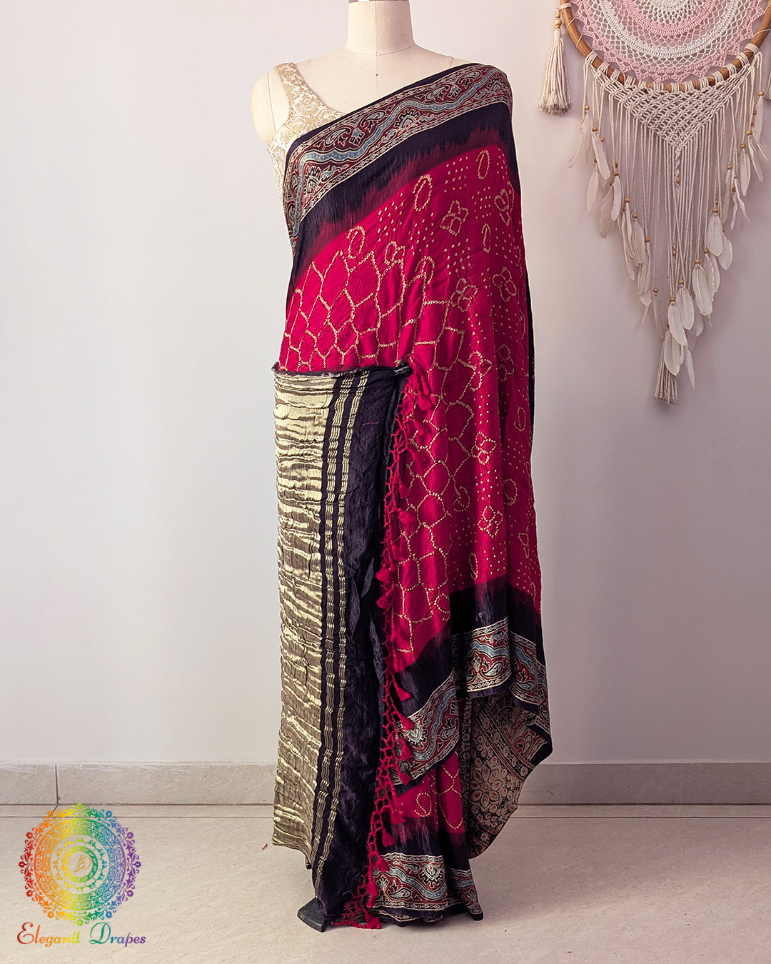 Red gaji silk bandhani saree on mannequin showcasing Ajrakh border detail