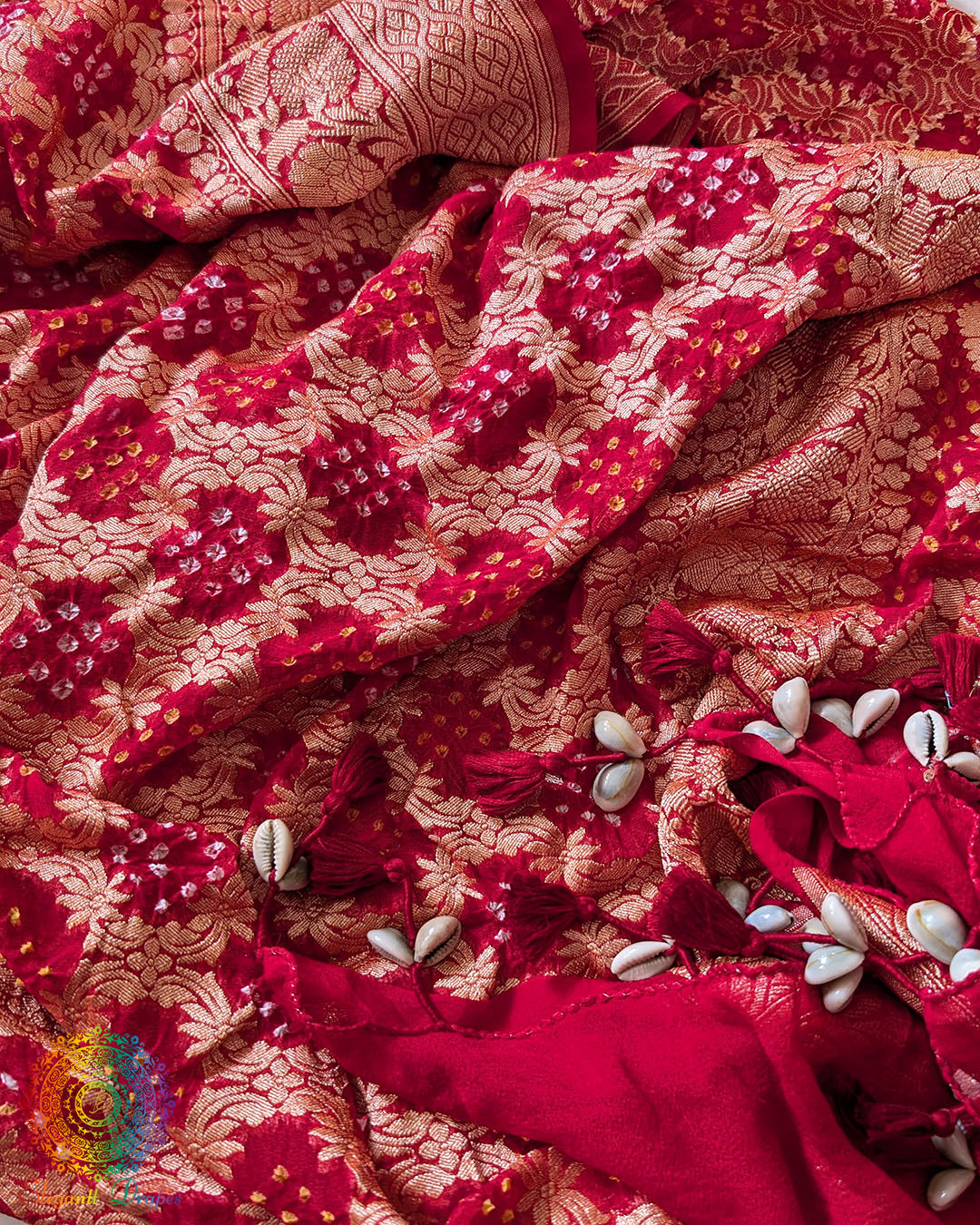Close-up of traditional kodi tassels, zari border, and Bandhani motifs on bridal red Banarasi georgette Gharchola Bandhani dupatta
