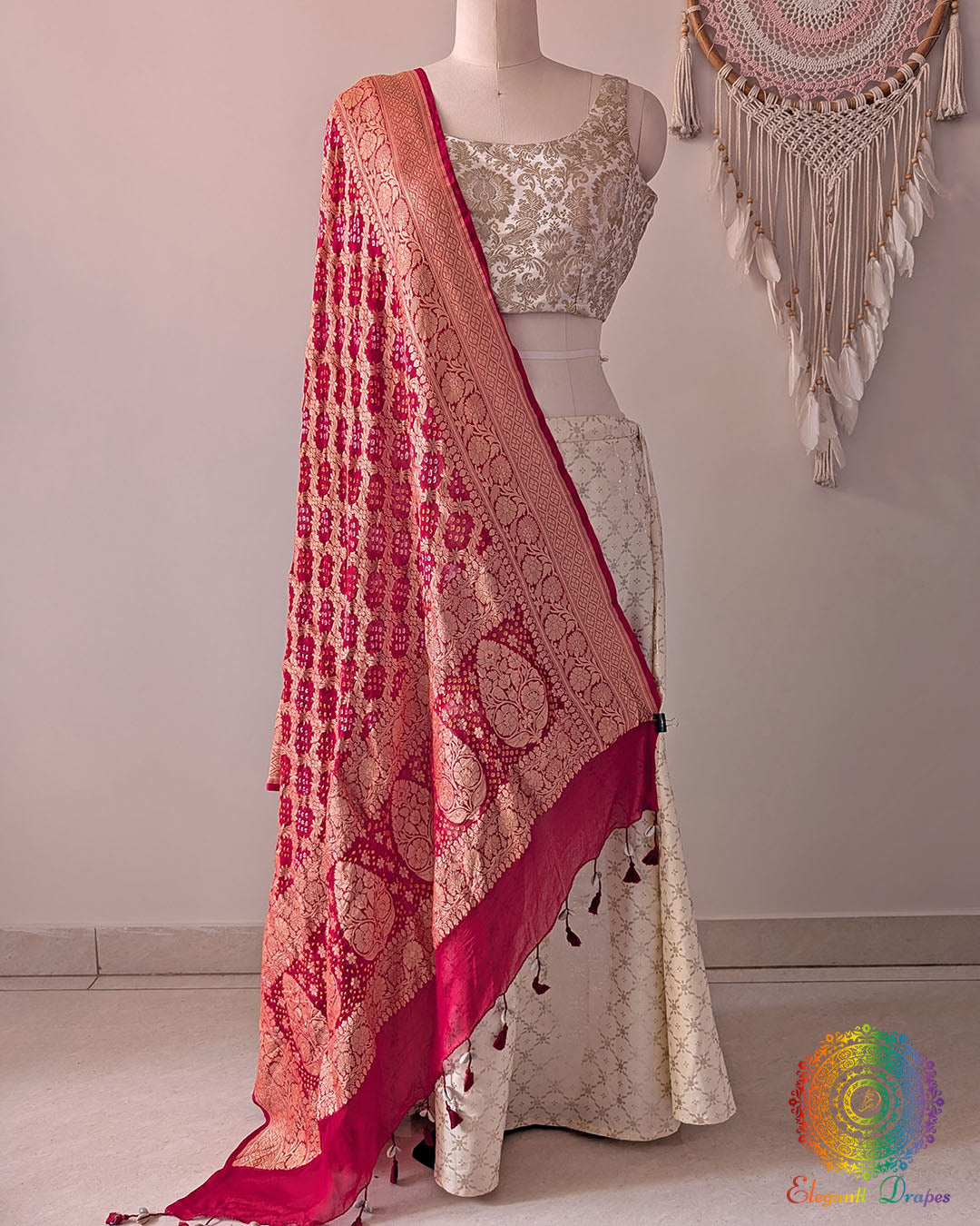 Bridal red Banarasi georgette Gharchola Bandhani dupatta draped on mannequin with zari border and kodi tassels