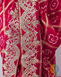 Close-up of the border of the Red Gaji Silk Gharchola Saree, showcasing the intricate Gota Patti embellishments, traditional patterns and rich Gaji Silk texture.