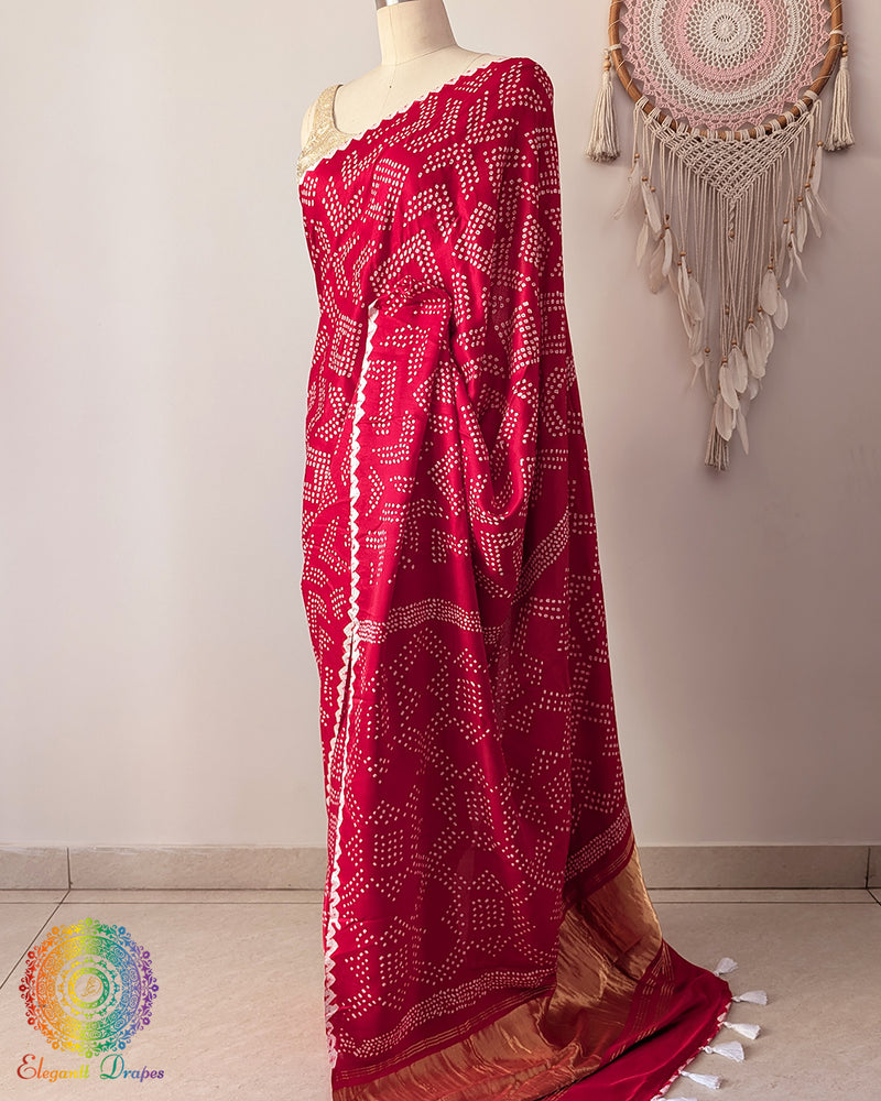 Side angle view of red bandhani silk saree on mannequin highlighting palla fall