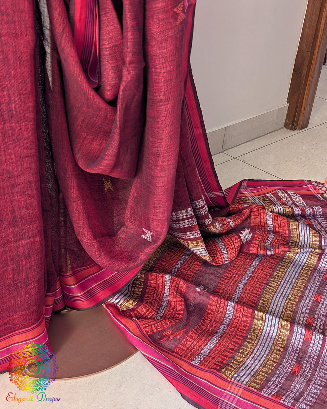 Pleats detail of red linen saree showing texture and structured drape