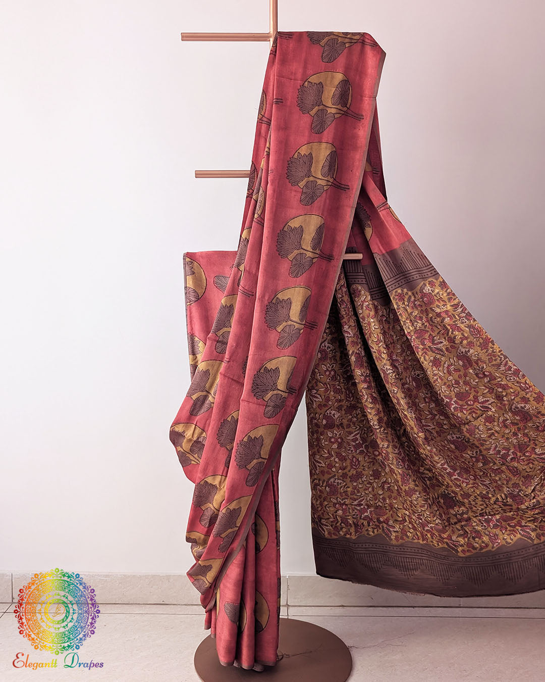 Red Nashpal Pomegranate Ajrakh Modal Tussar Silk Saree with the palla neatly pleated, highlighting the floral patterns and layered red fabric.