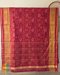 Open palla view of festive red Rajkot Patola pure mulberry silk saree displaying woven design