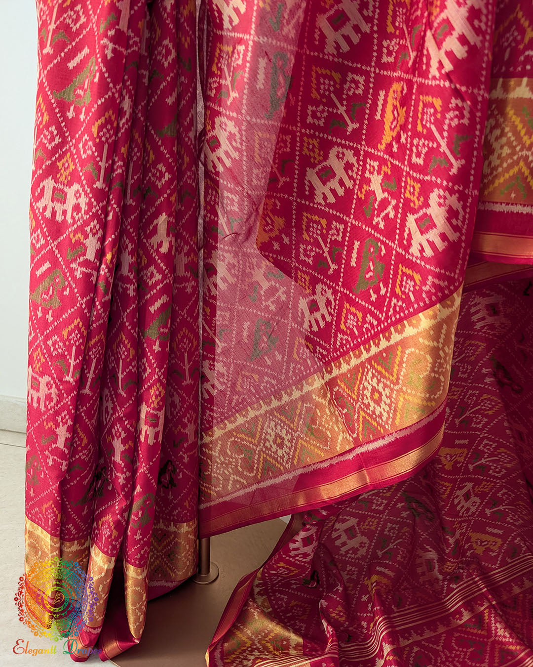 Pleats close up on festive red Patola silk saree showcasing weave and traditional pattern