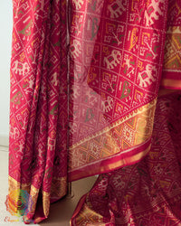 Pleats close up on festive red Patola silk saree showcasing weave and traditional pattern