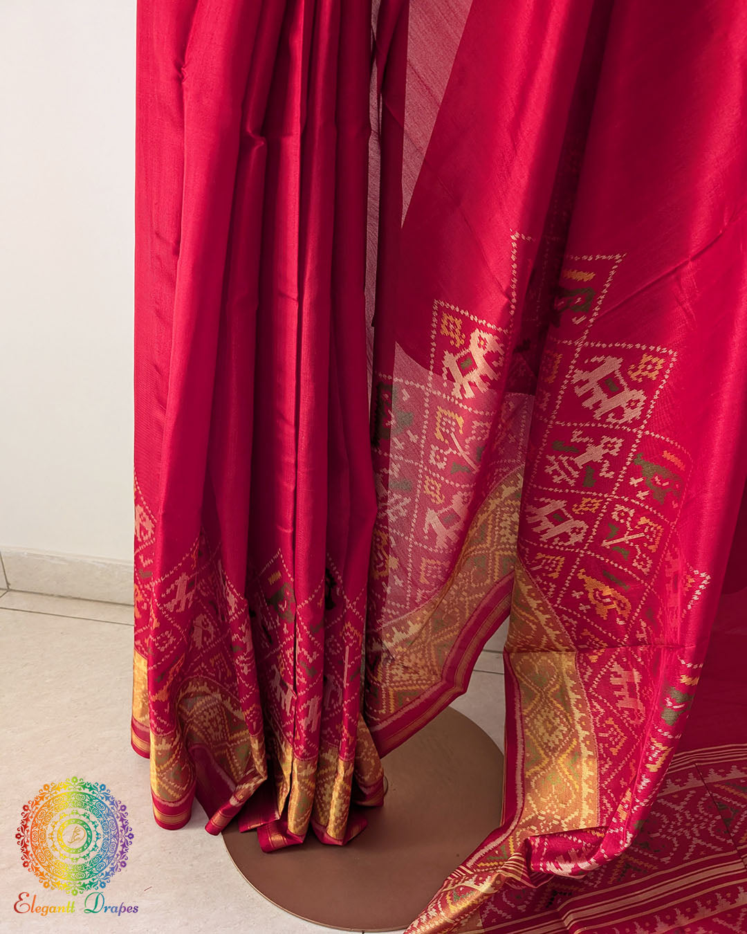 Side angle view of red Rajkot Patola silk saree highlighting traditional weave