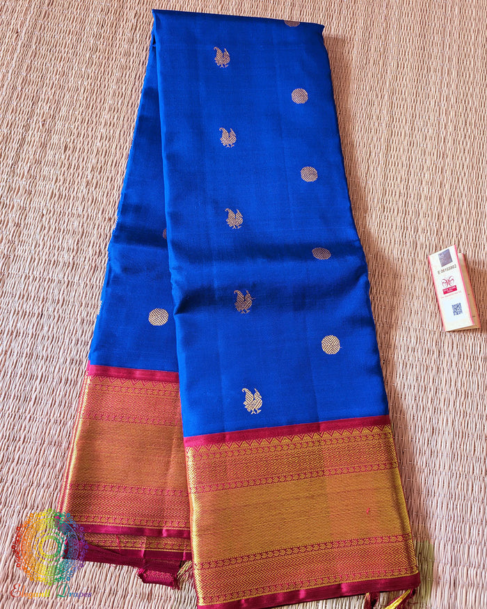 Folded royal blue Kanjivaram silk saree showing red border and 2 gram zari weaving