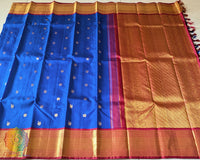 Full royal blue Kanjivaram silk saree laid open showing red palla and woven design
