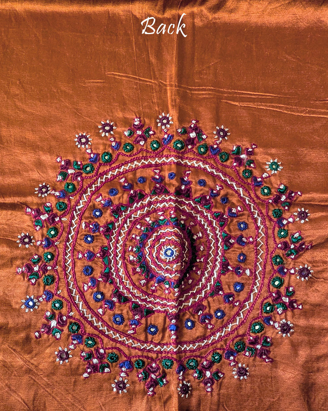 Close-up of large circular Bavadiya handwork motif on Rust Orange Mashru Silk Blouse Piece back
