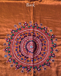 Close-up of large circular Bavadiya handwork motif on Rust Orange Mashru Silk Blouse Piece back